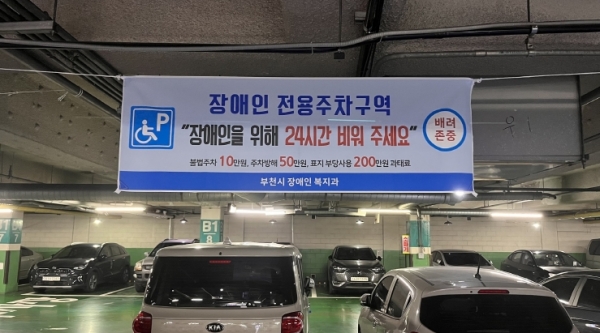 장애인 전용주차구역 불법주차 금지 현수막을 부착한 모습