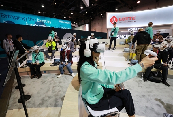 세계 최대 가전·IT(정보기술) 박람회 CES 2023 개막일인 지난 1월 5일(현지시간) 미국 네바다주 라스베이거스 컨벤션 센터 중앙홀의 롯데정보통신 전시관을 찾은 관람객들이 쇼핑 VR 체험존에서 메타버스로 구현된 VR체험을 하고 있다